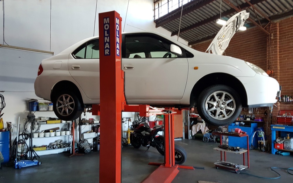 Inside the Lui's Mechanical Repairs workshop in Hamilton Hill, with a vehicle raised on the hoist